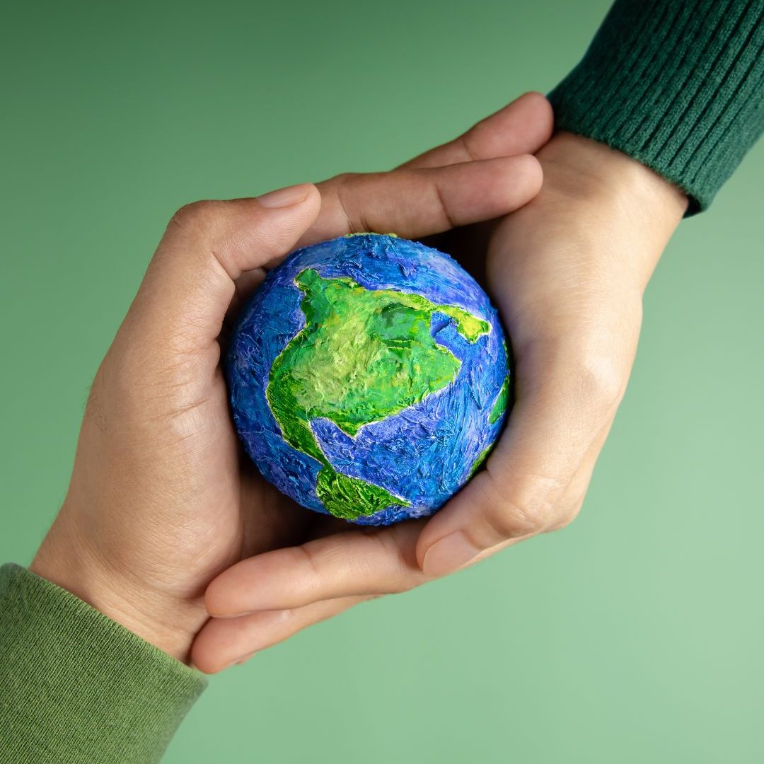 Duas Mãos Segurando uma Miniatura do Globo do Planeta Terra